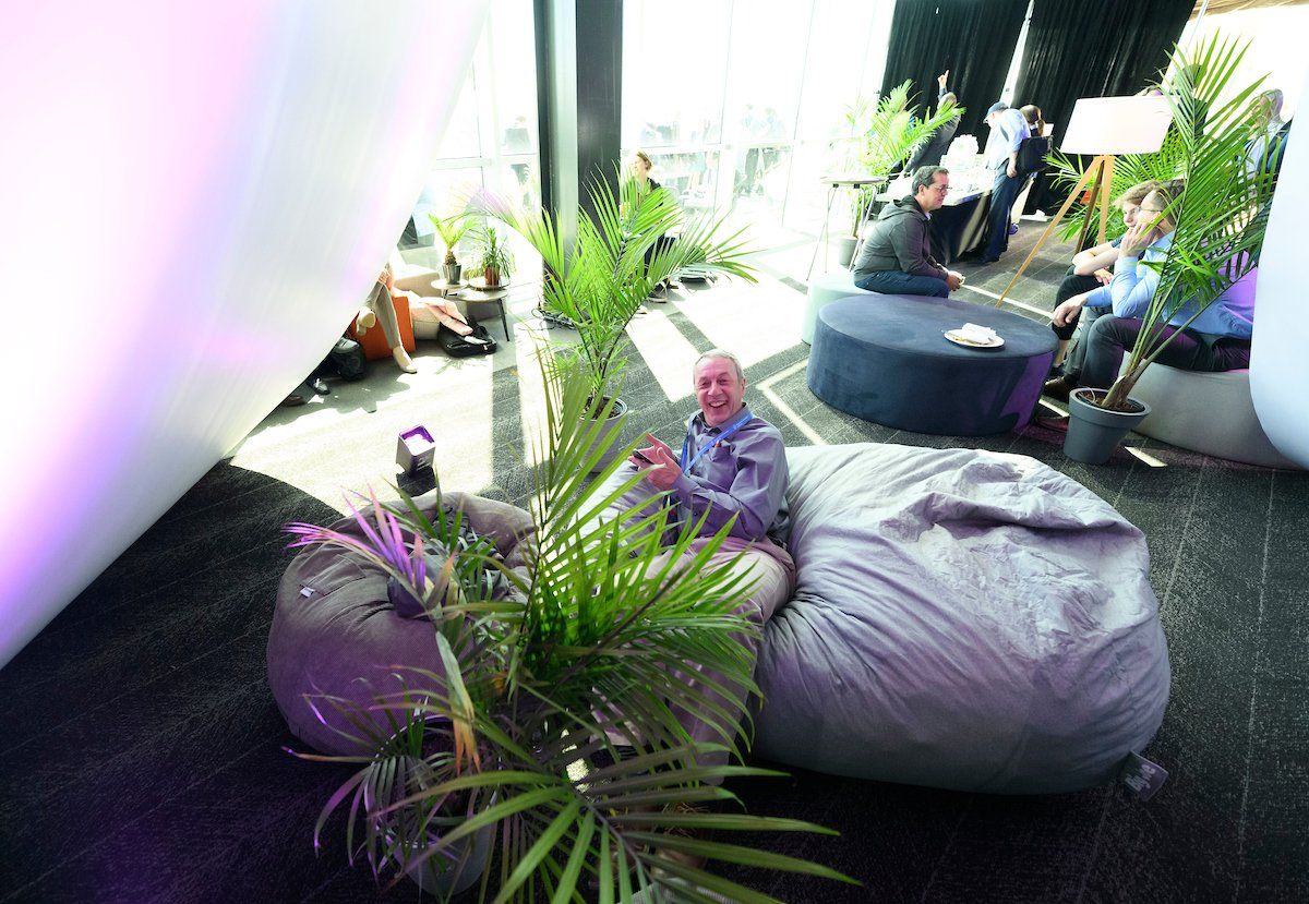 A man is sitting on a bean bag chair in a room.