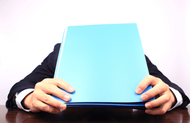 A person covering their face with a blue folder