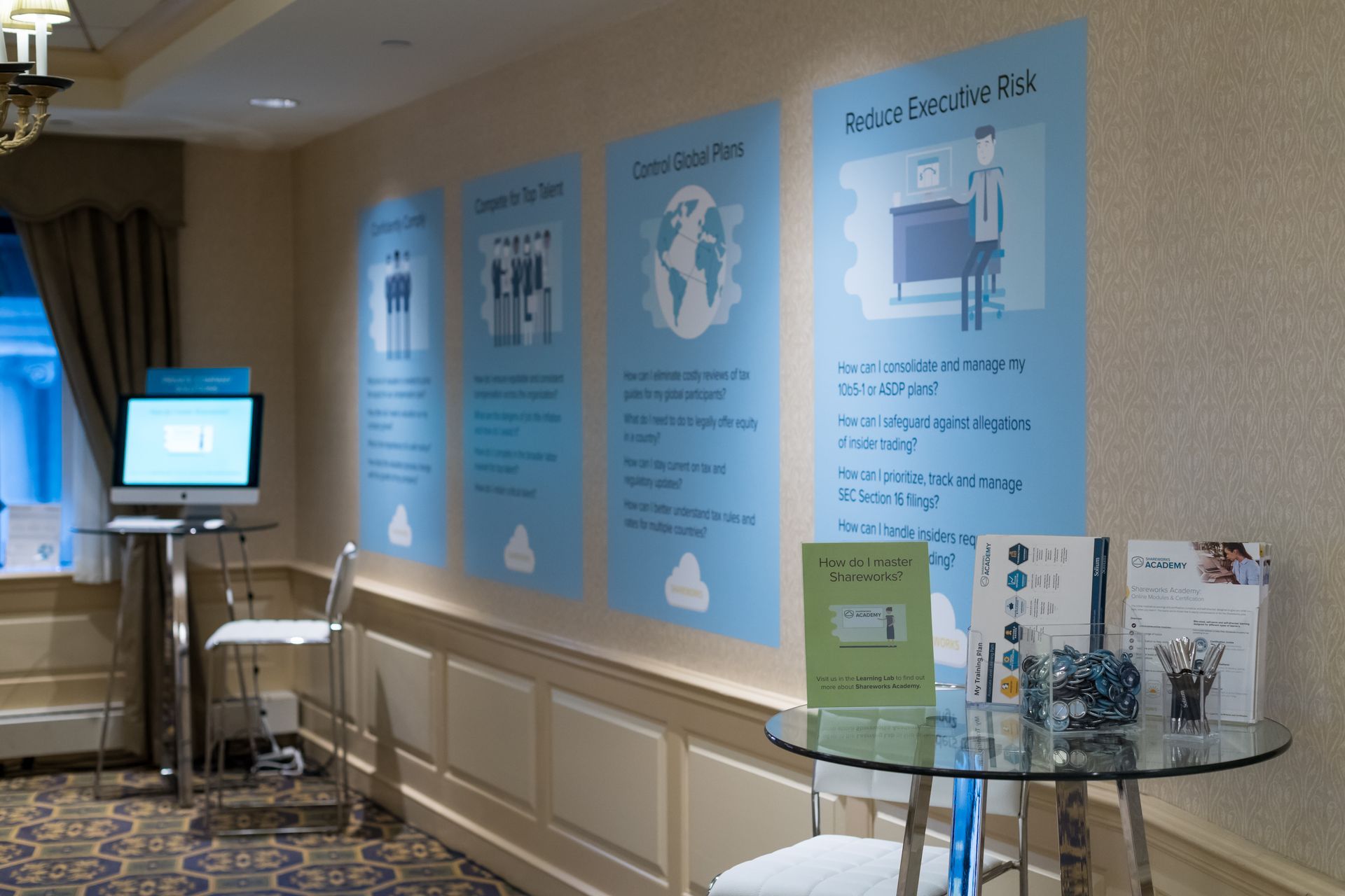 Event space with informational posters and a computer stand.