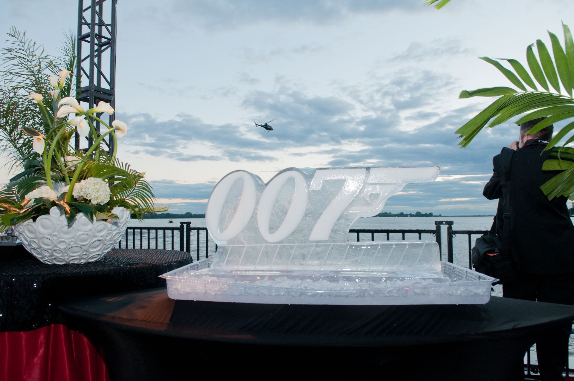 A man is standing in front of a 007 ice sculpture