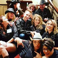 A group of people wearing cowboy hats are posing for a picture.