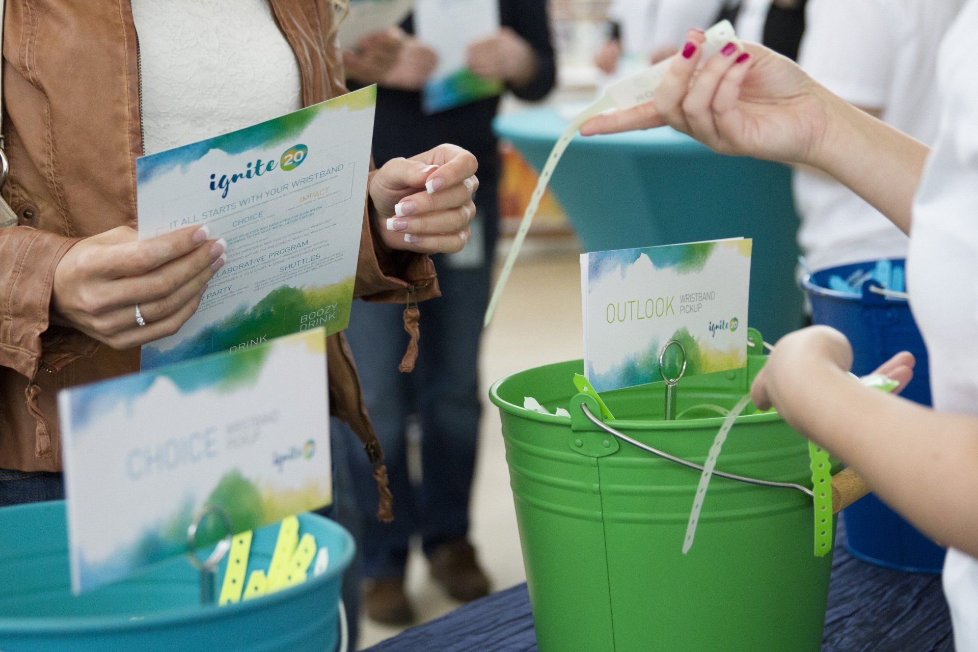 A woman is putting a piece of paper in a green bucket.