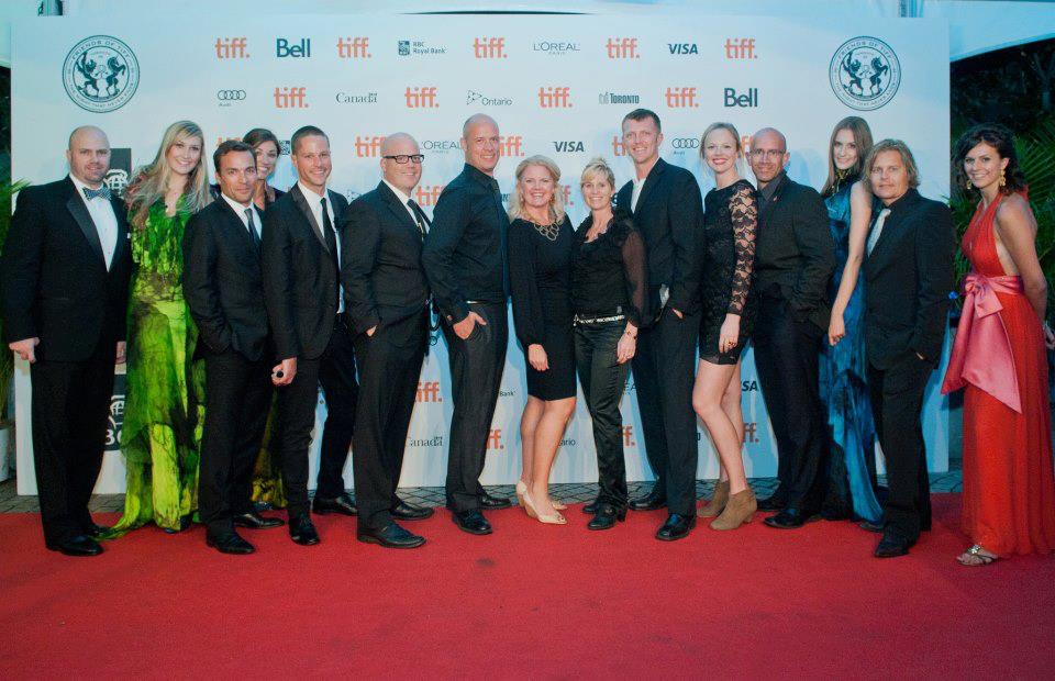 A group of people are posing for a picture on a red carpet.