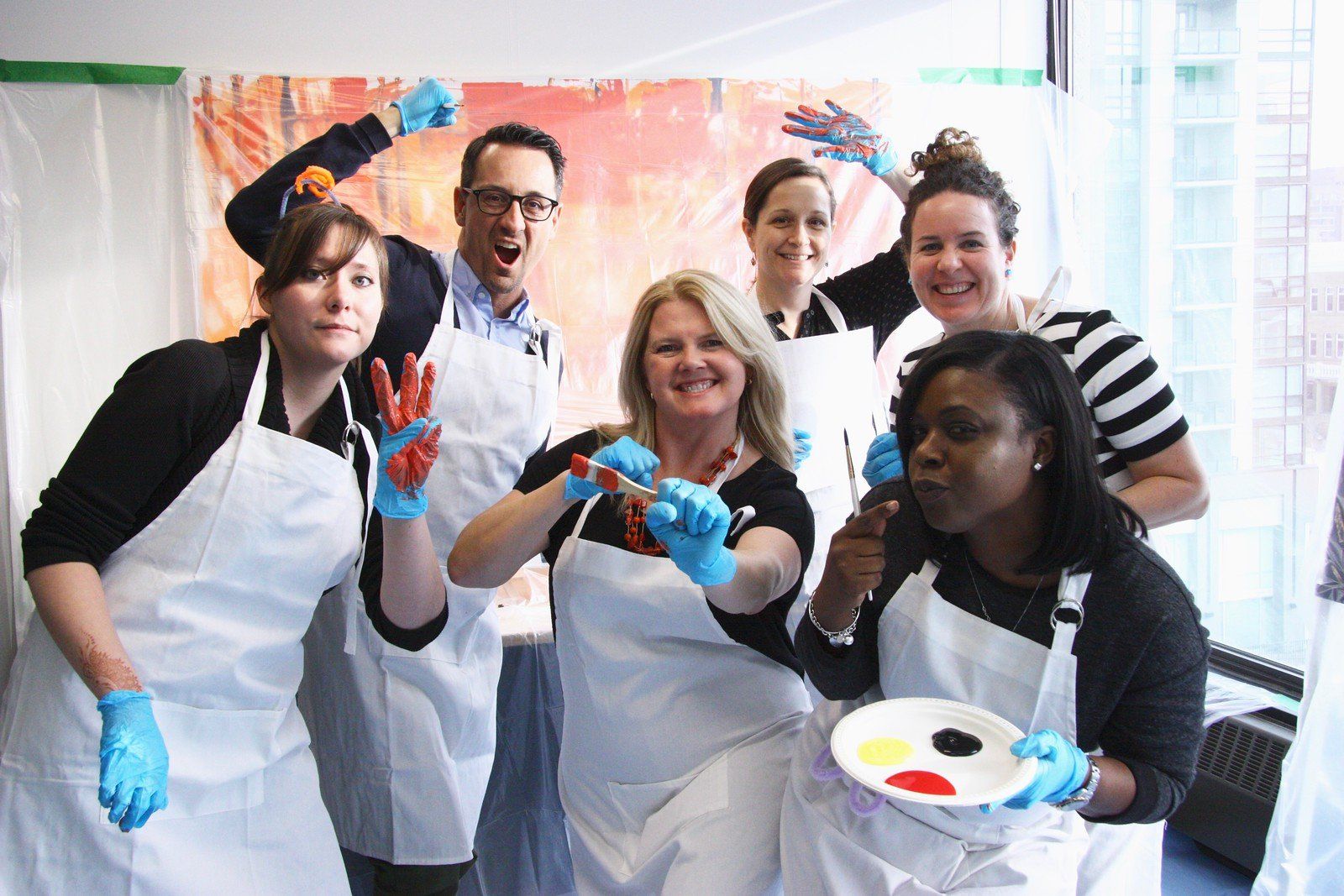 A group of people wearing aprons and blue gloves are posing for a picture.