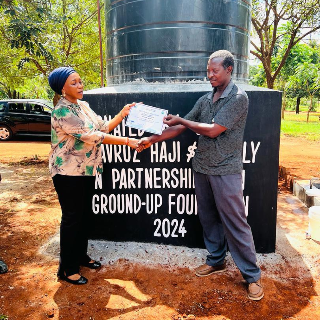 A man and a woman are standing in front of a sign that says ground-up fou 2024