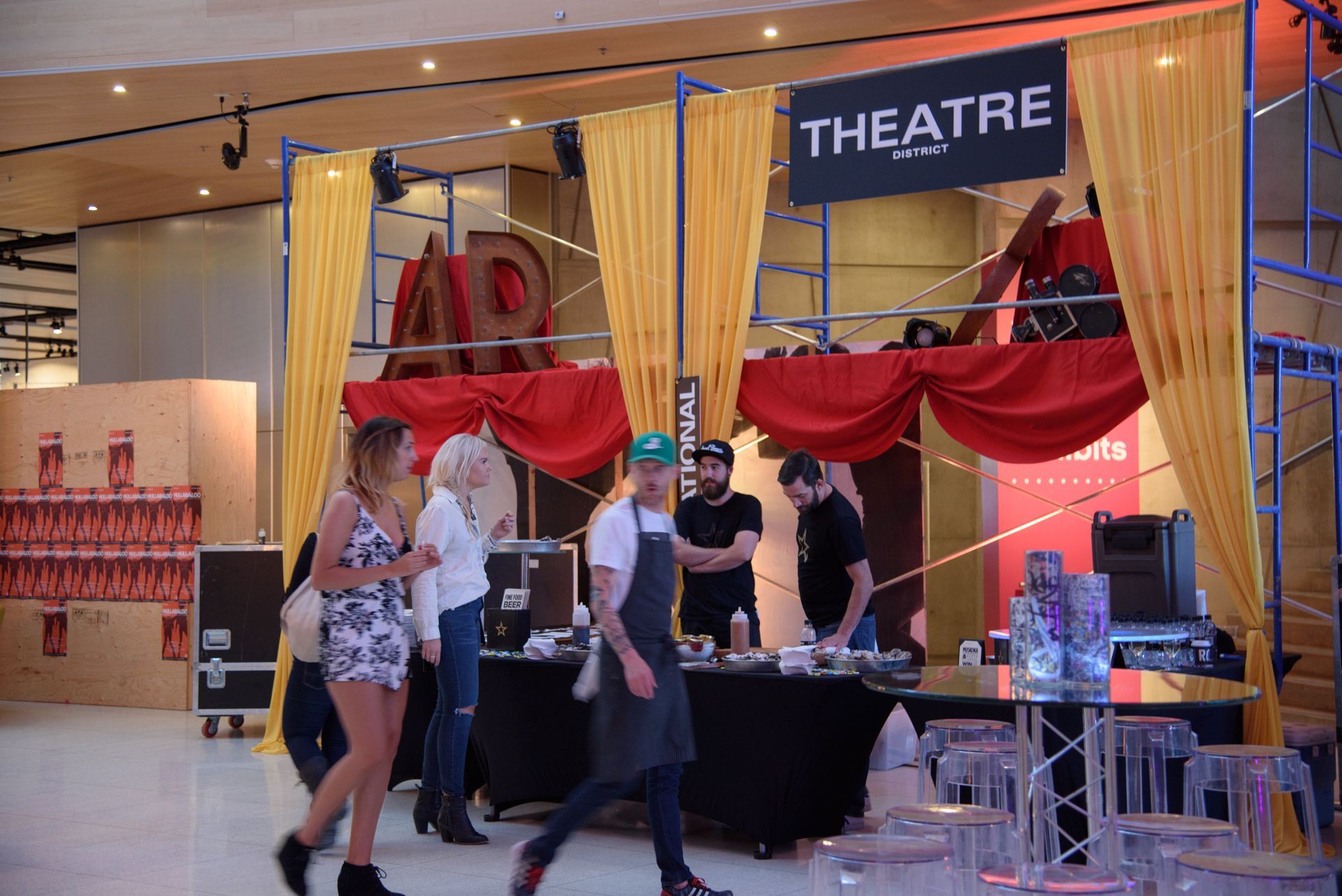 A group of people are standing in front of a theatre sign.