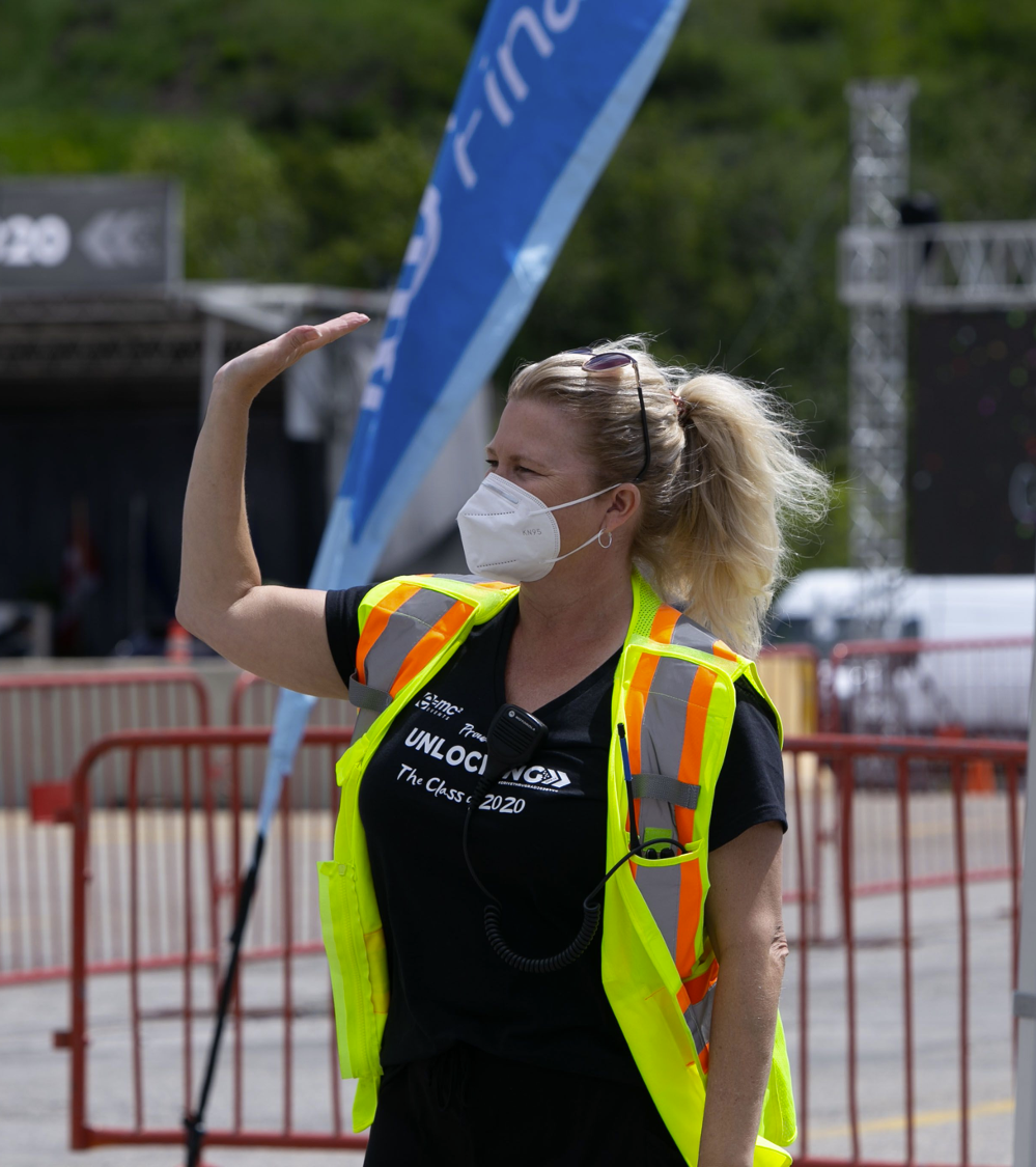 A woman wearing a mask and a safety vest