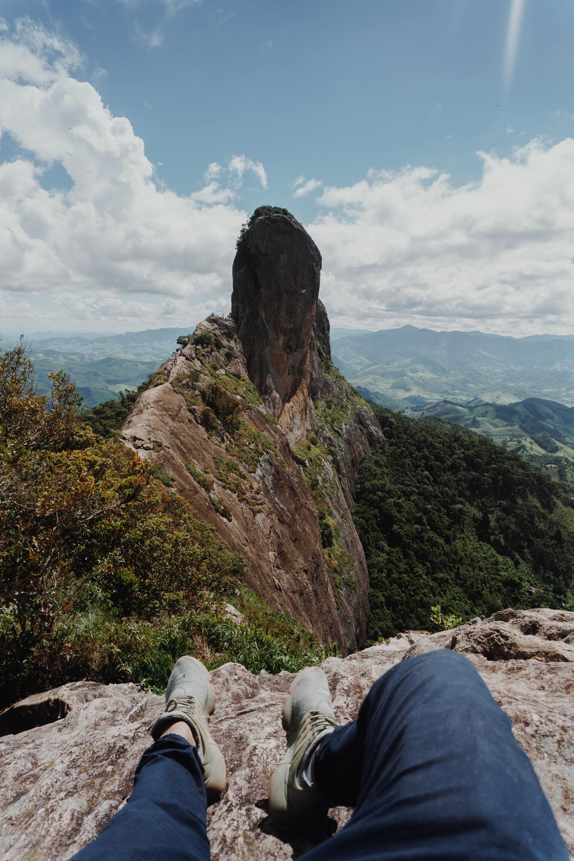 A person laying on top of a rocky mountain with their feet up