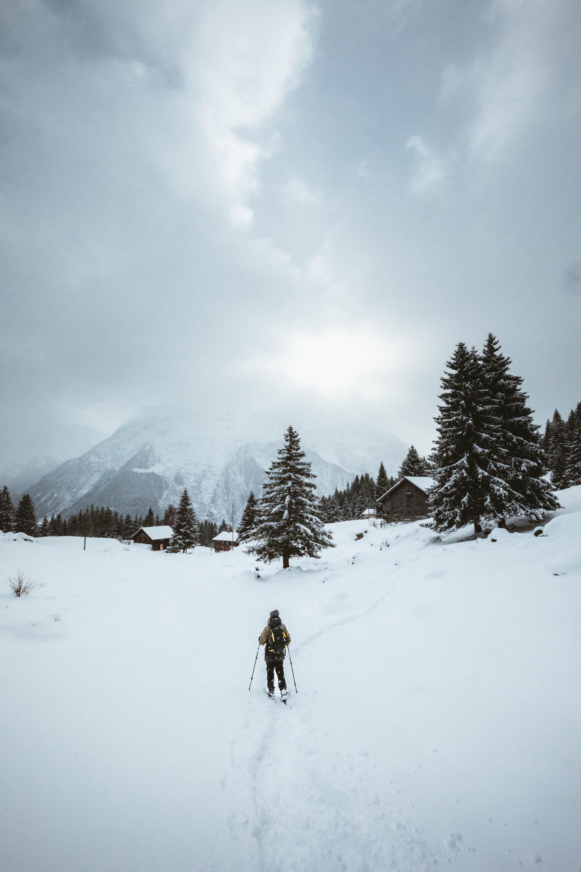 A person is walking through a snowy field in the mountains.