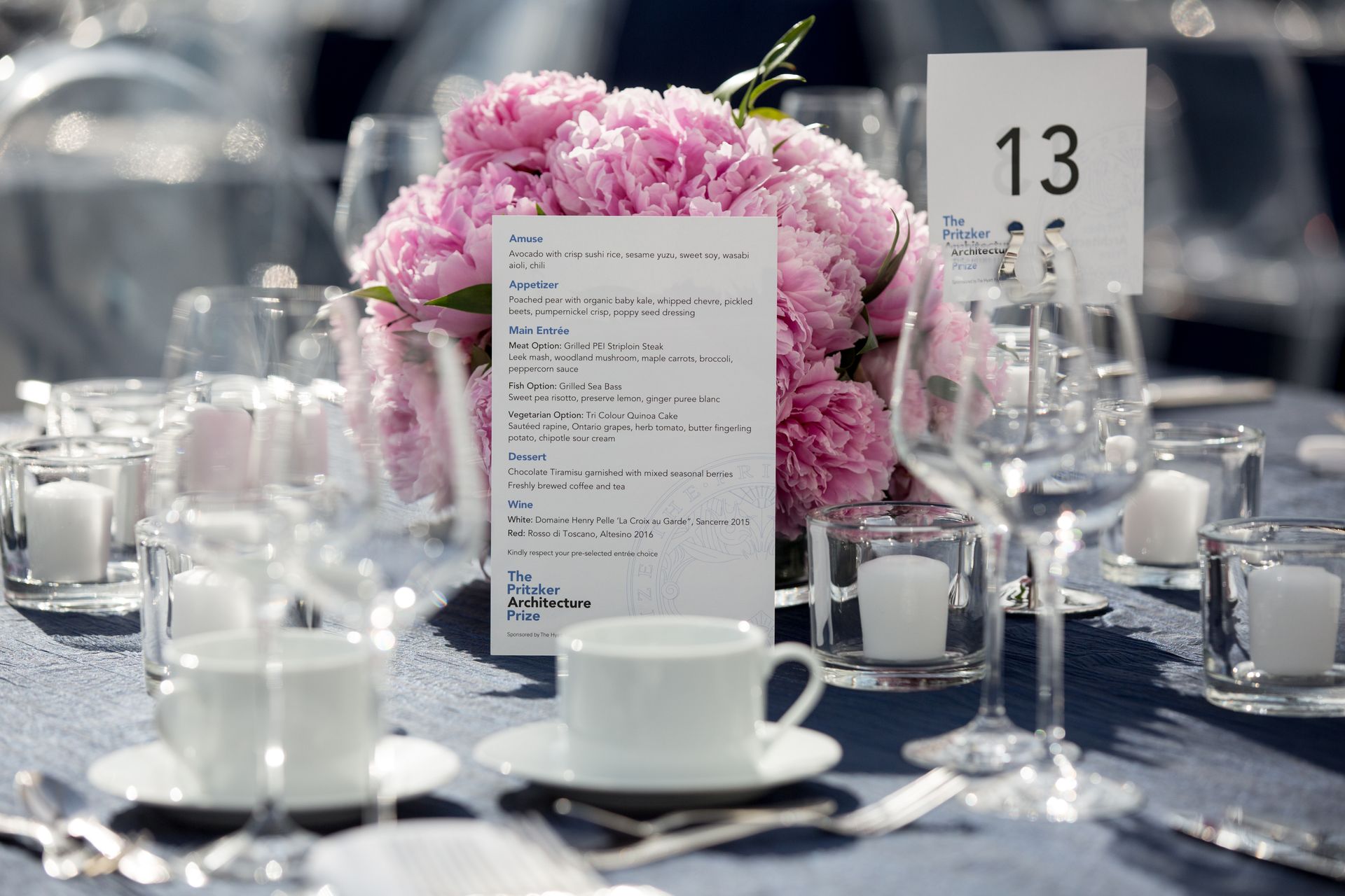 A table setting with pink flowers and a menu on it
