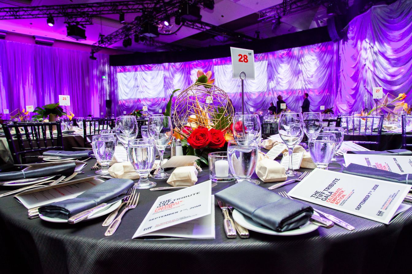 A table set for a dinner party in a large room with purple walls.
