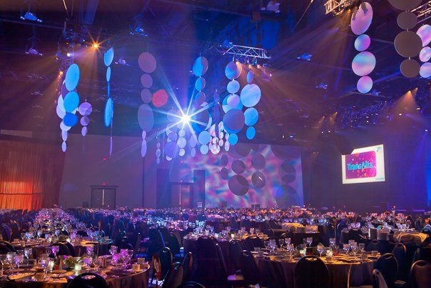 A large room with tables and chairs set up for a party.