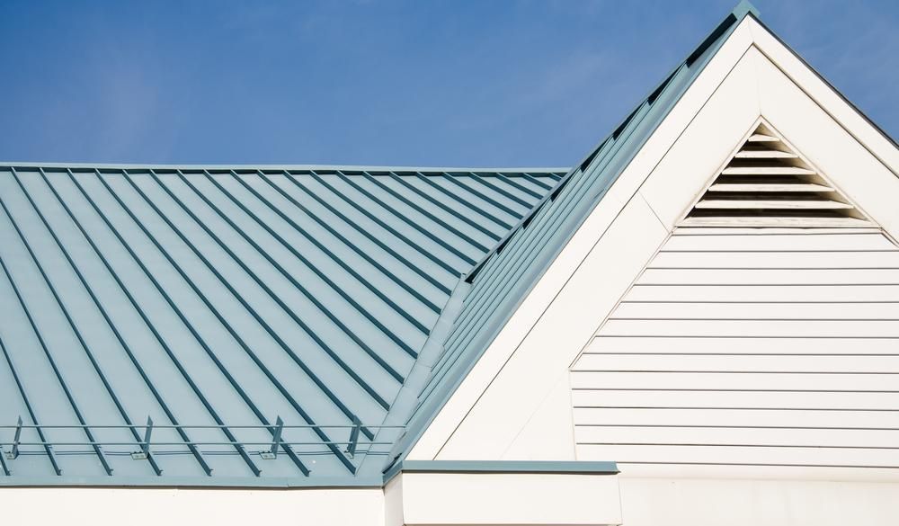 A White House With A Blue Roof And A Blue Sky In The Background — APEX Painting & Maintenance In Flinders, NSW