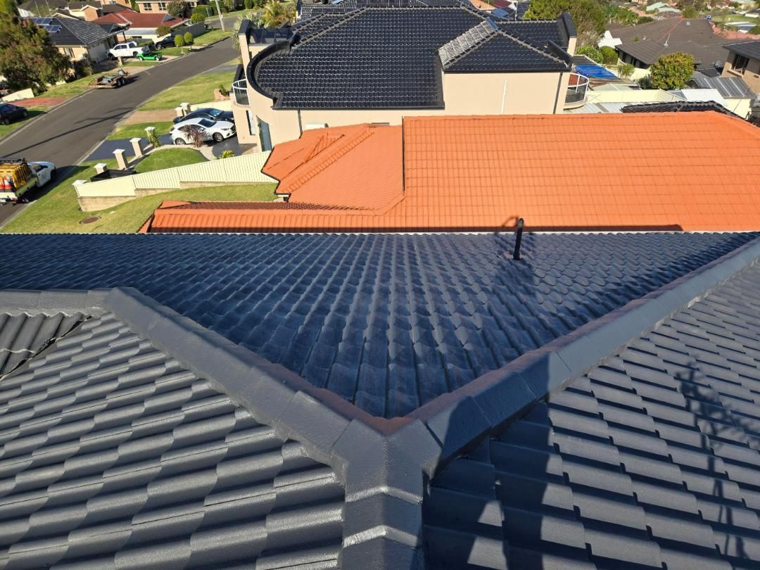 An Aerial View Of A House With A Black Roof And Red Tiles — APEX Painting & Maintenance In Shellharbour, NSW