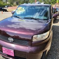 Purple SUV parked outdoors with a pink sign in the windshield and license plate visible