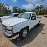 White pickup truck parked outdoors on a sunny day, viewed from the front-left side.