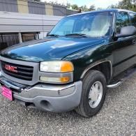 Black GMC pickup truck parked outside a building.