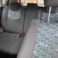 Car interior with gray seats and patterned seat covers in the back and front passenger seats
