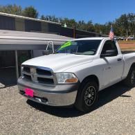 White Ram pickup truck parked outdoors in front of a building on a sunny day.