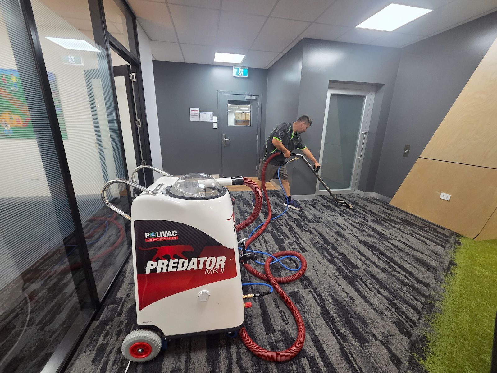 Worker Using a Carpet Cleaning Machine in a Hallway — Pristine Cleaning Bundaberg In Kalkie, QLD