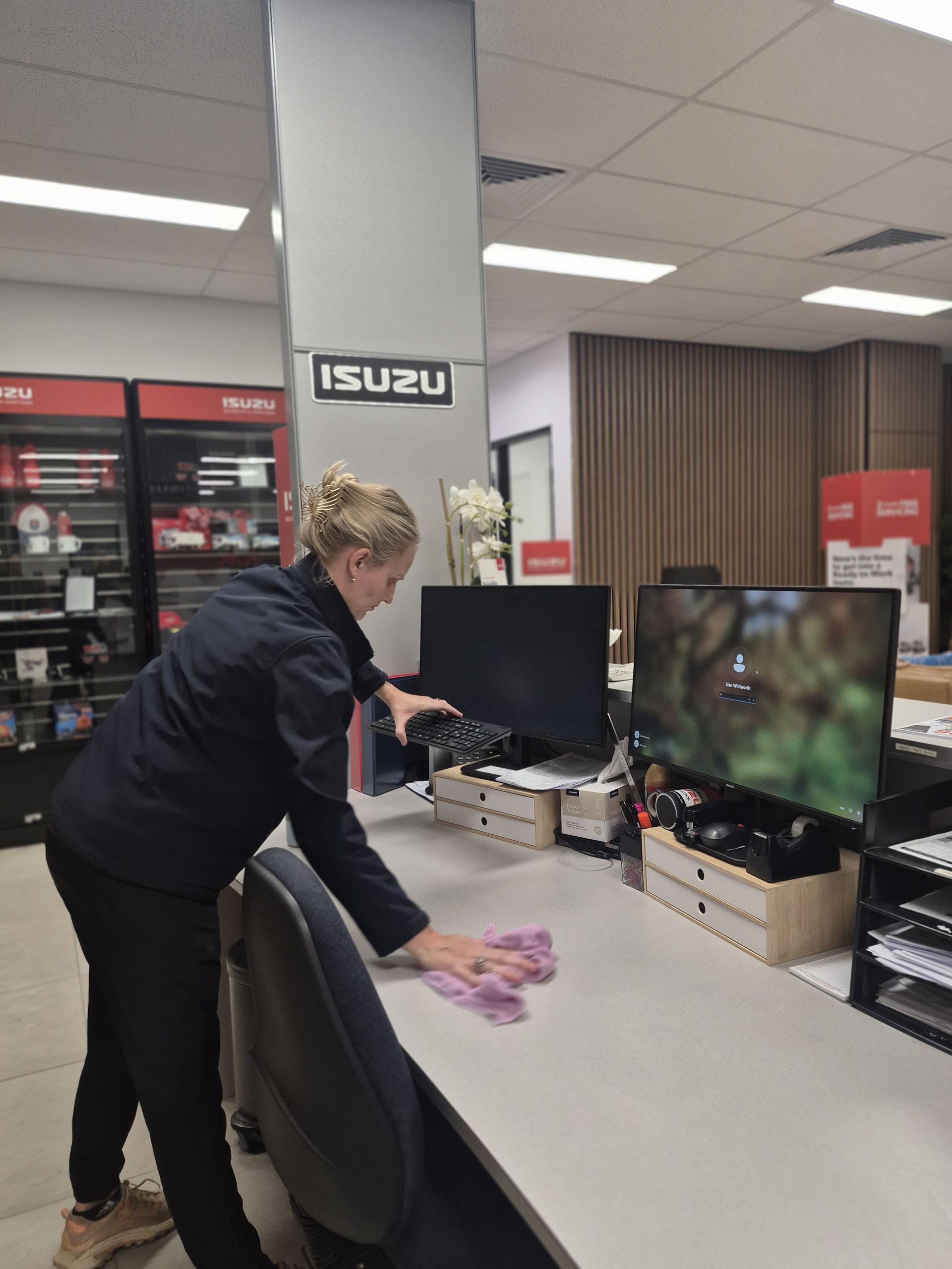 Person Cleaning a Desk in an Office Showroom — Pristine Cleaning Bundaberg In Kalkie, QLD
