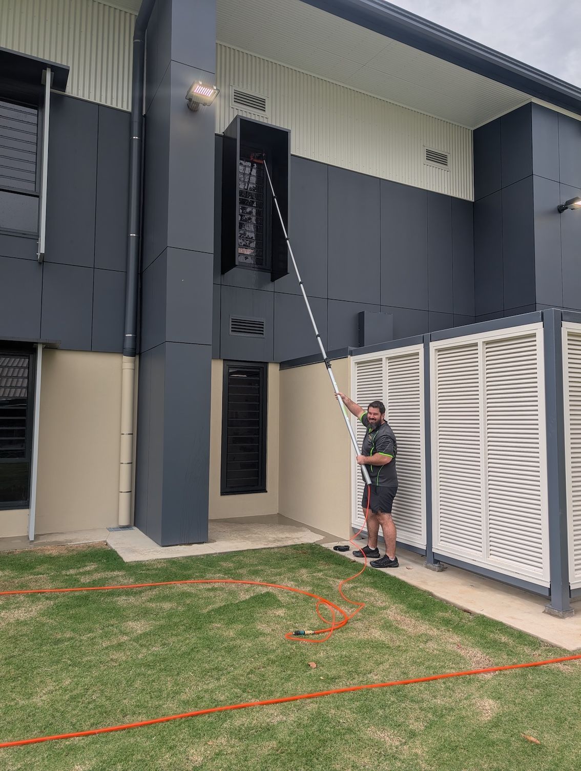 A Man Cleaning a Building Exterior — Pristine Cleaning Bundaberg In Kalkie, QLD