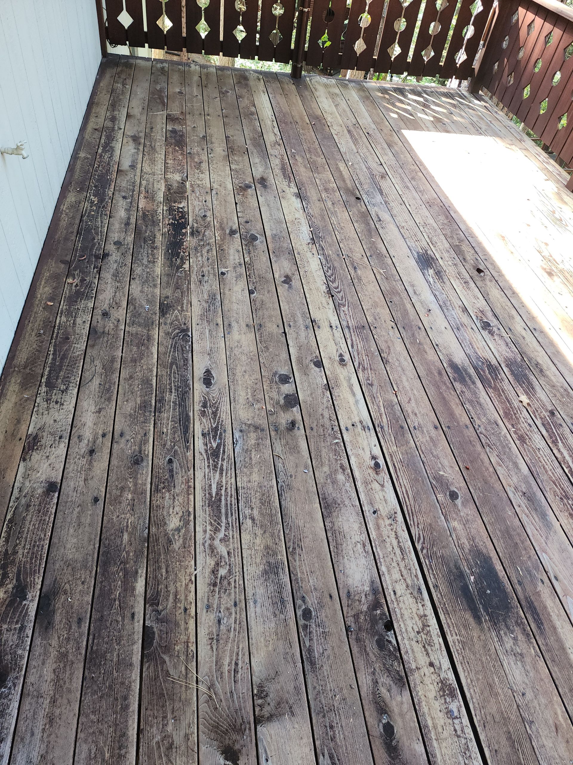 A close up of a wooden deck with a fence in the background.