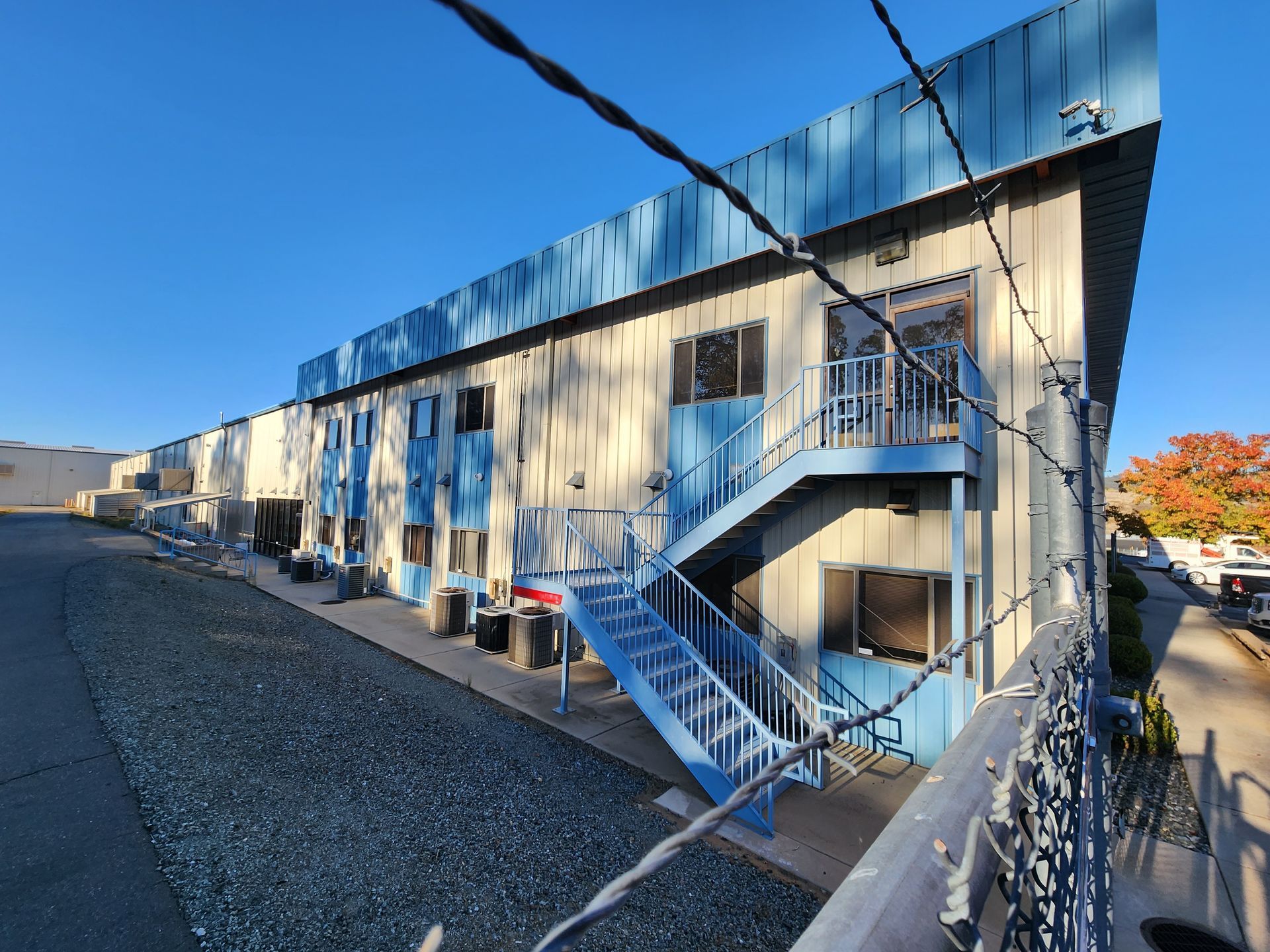 A building with blue stairs and a barbed wire fence around it