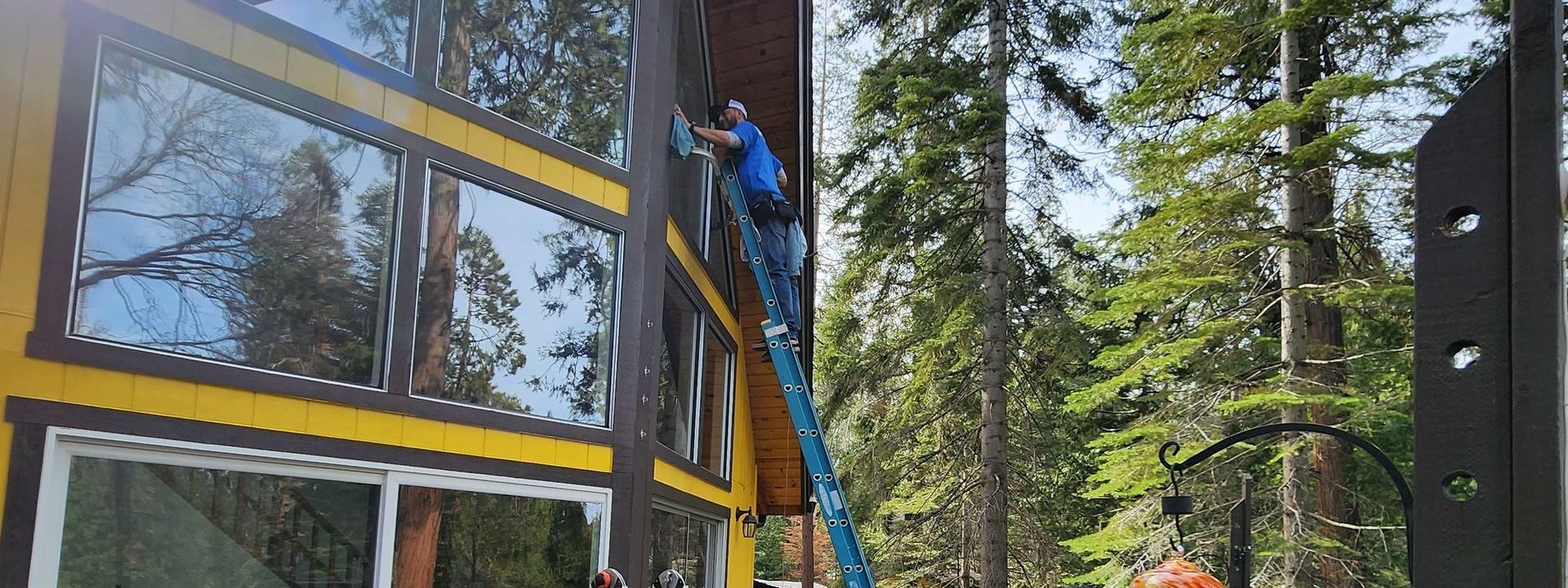 A man is cleaning the windows of a building with a crane.