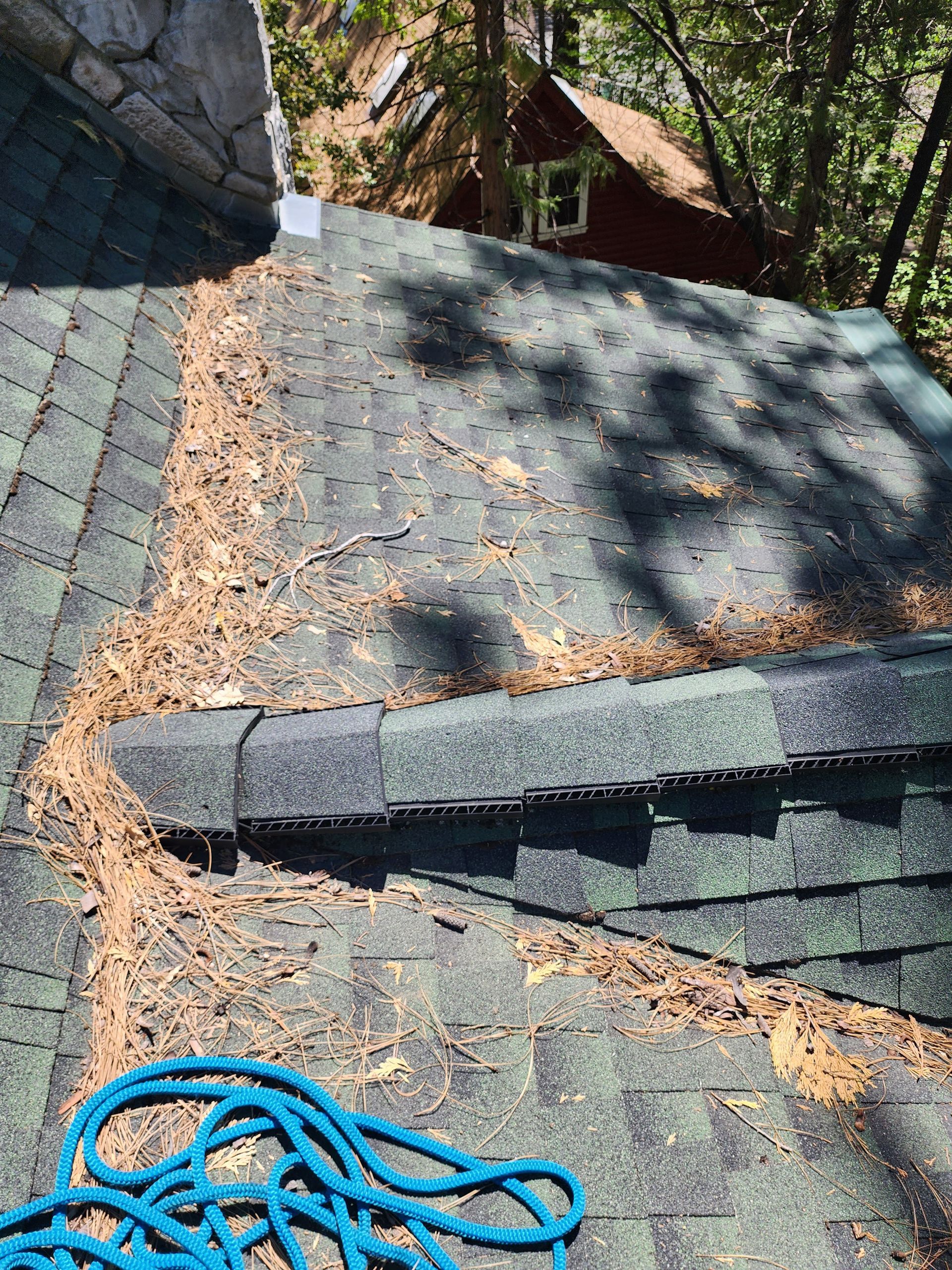 A blue rope is laying on top of a roof.