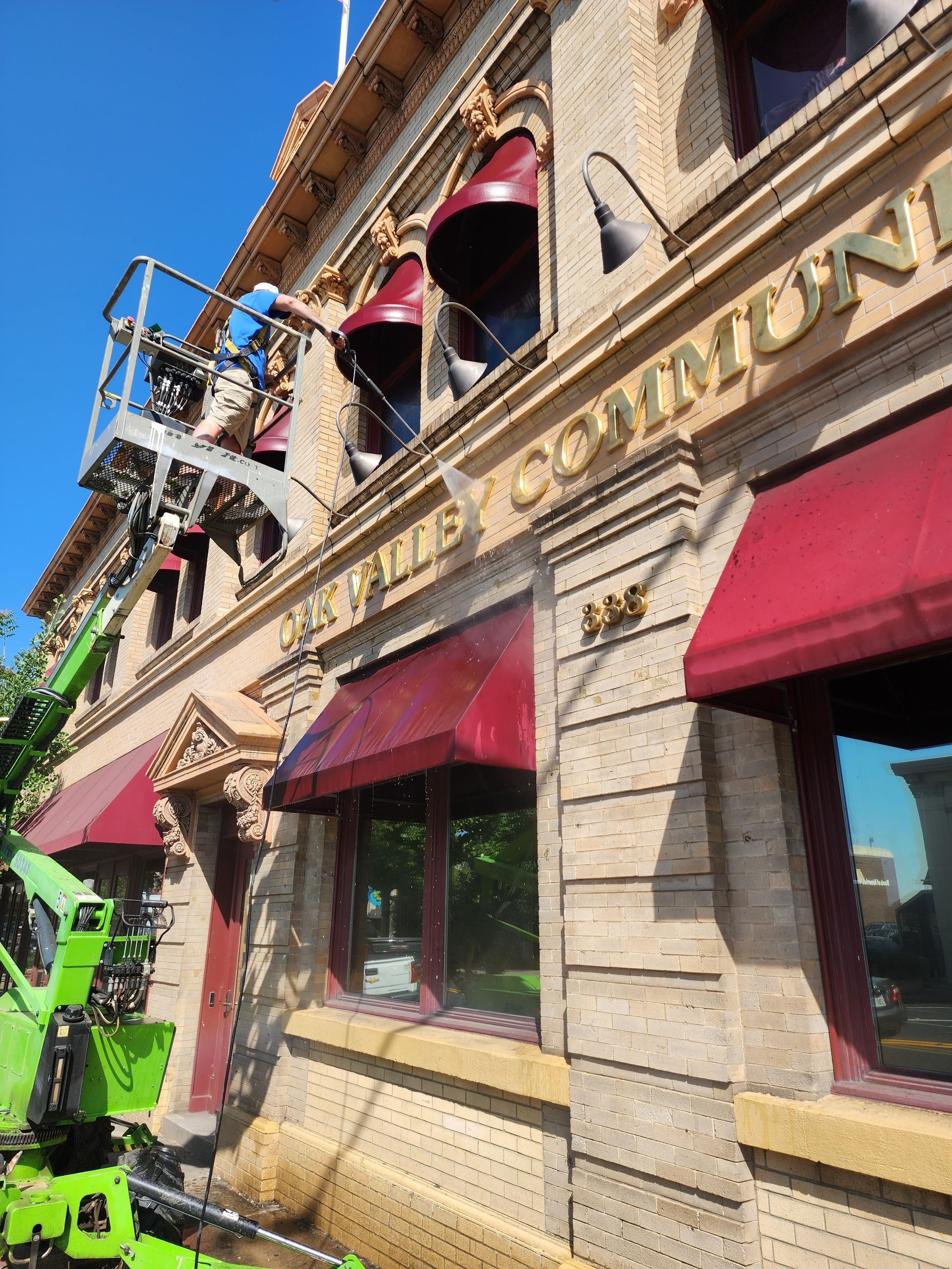 A green crane is working on the side of a building.