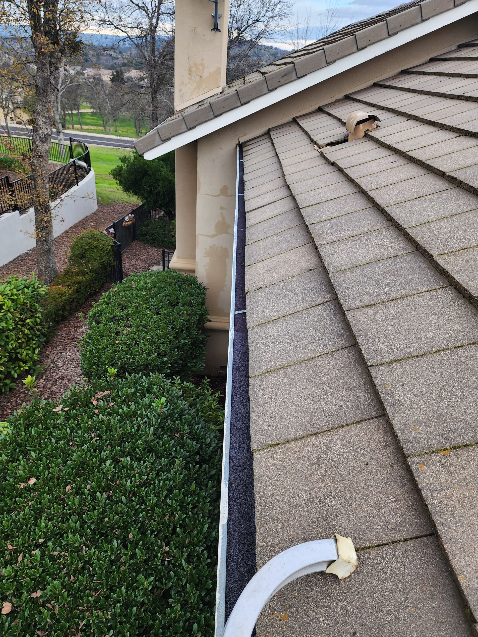 There is a gutter on the roof of a house.