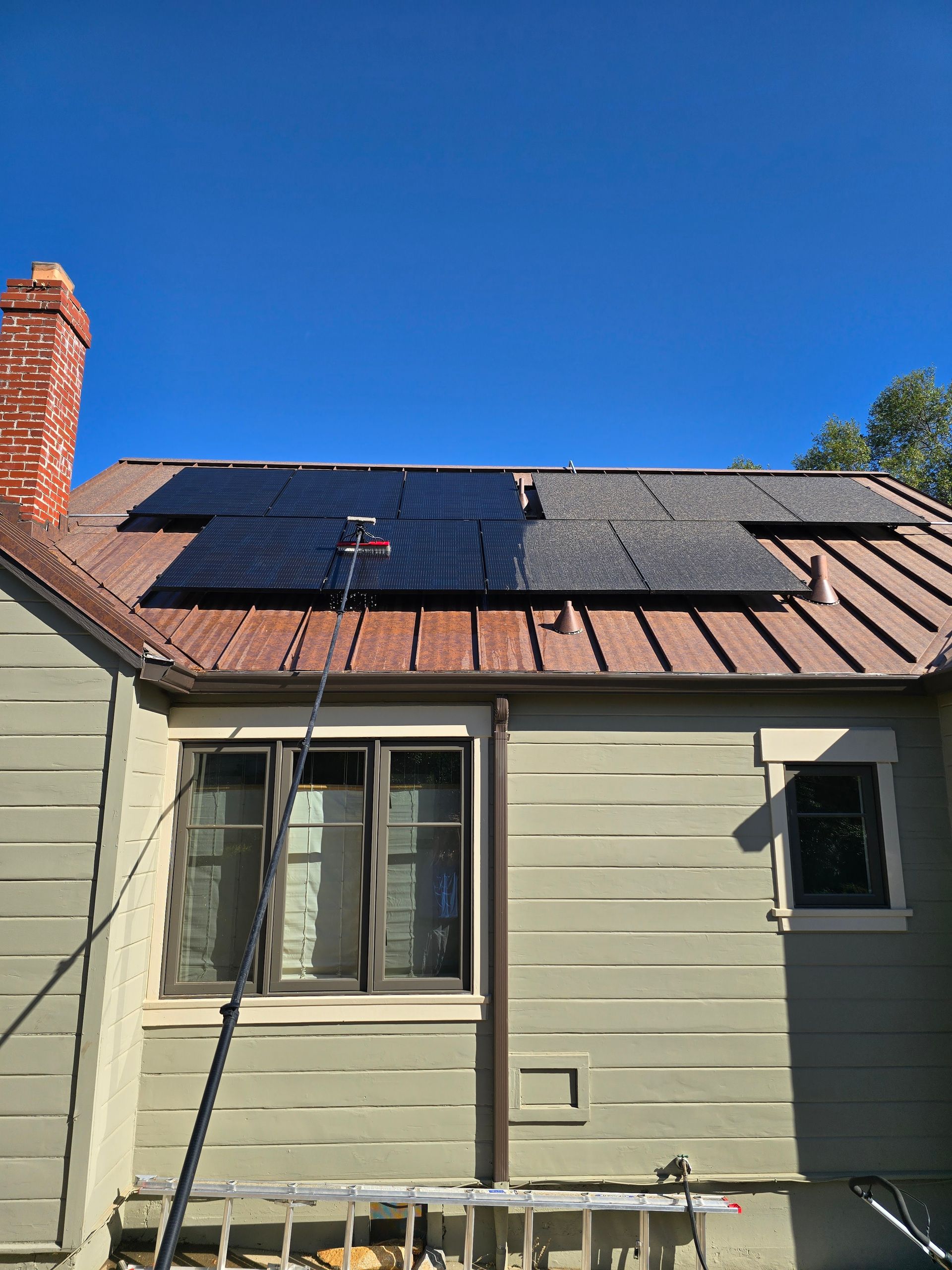 A house with solar panels on the roof and a window.