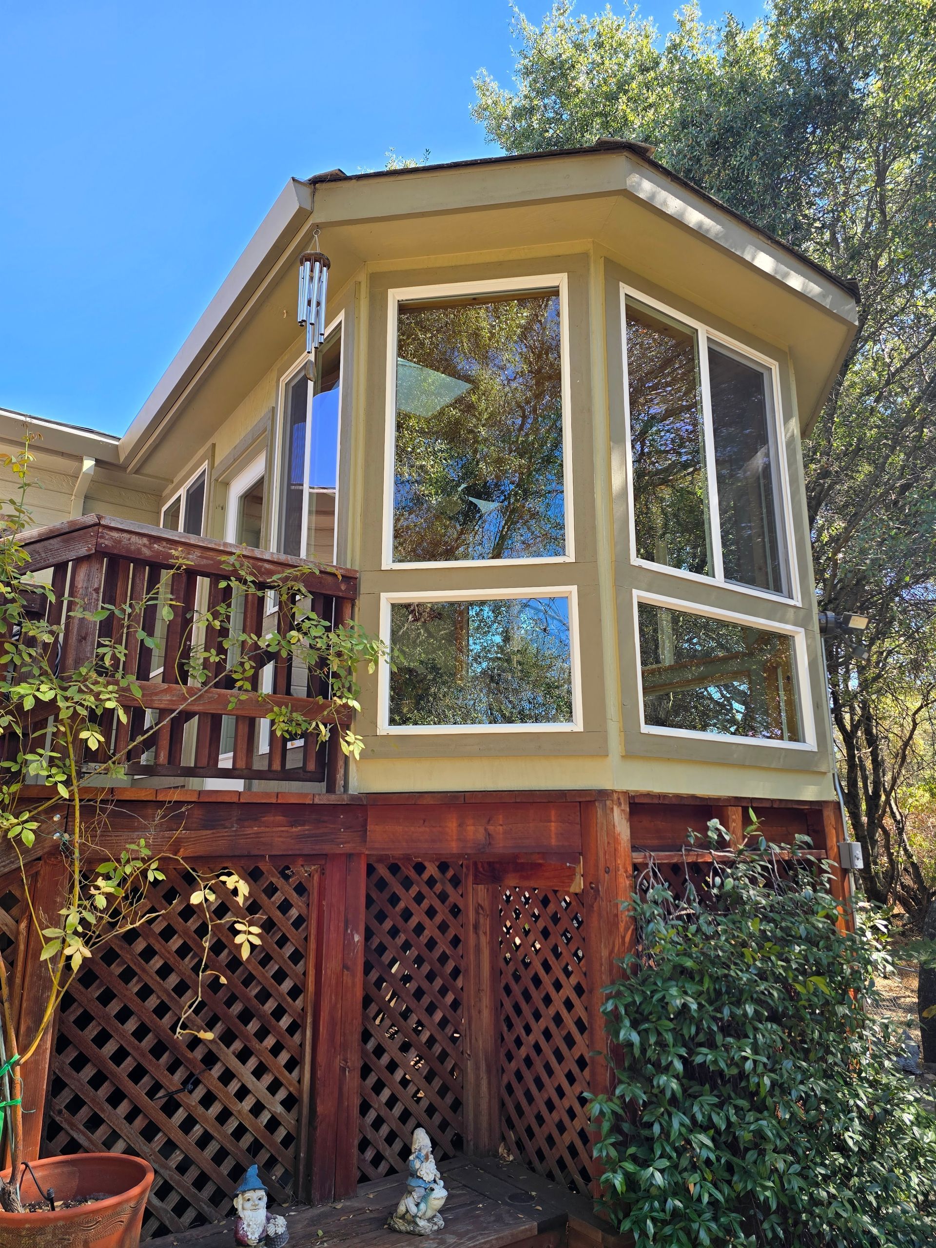 A large house with a lot of windows is surrounded by trees and bushes.
