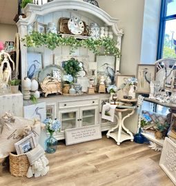 A room with a hutch filled with lots of decorations.
