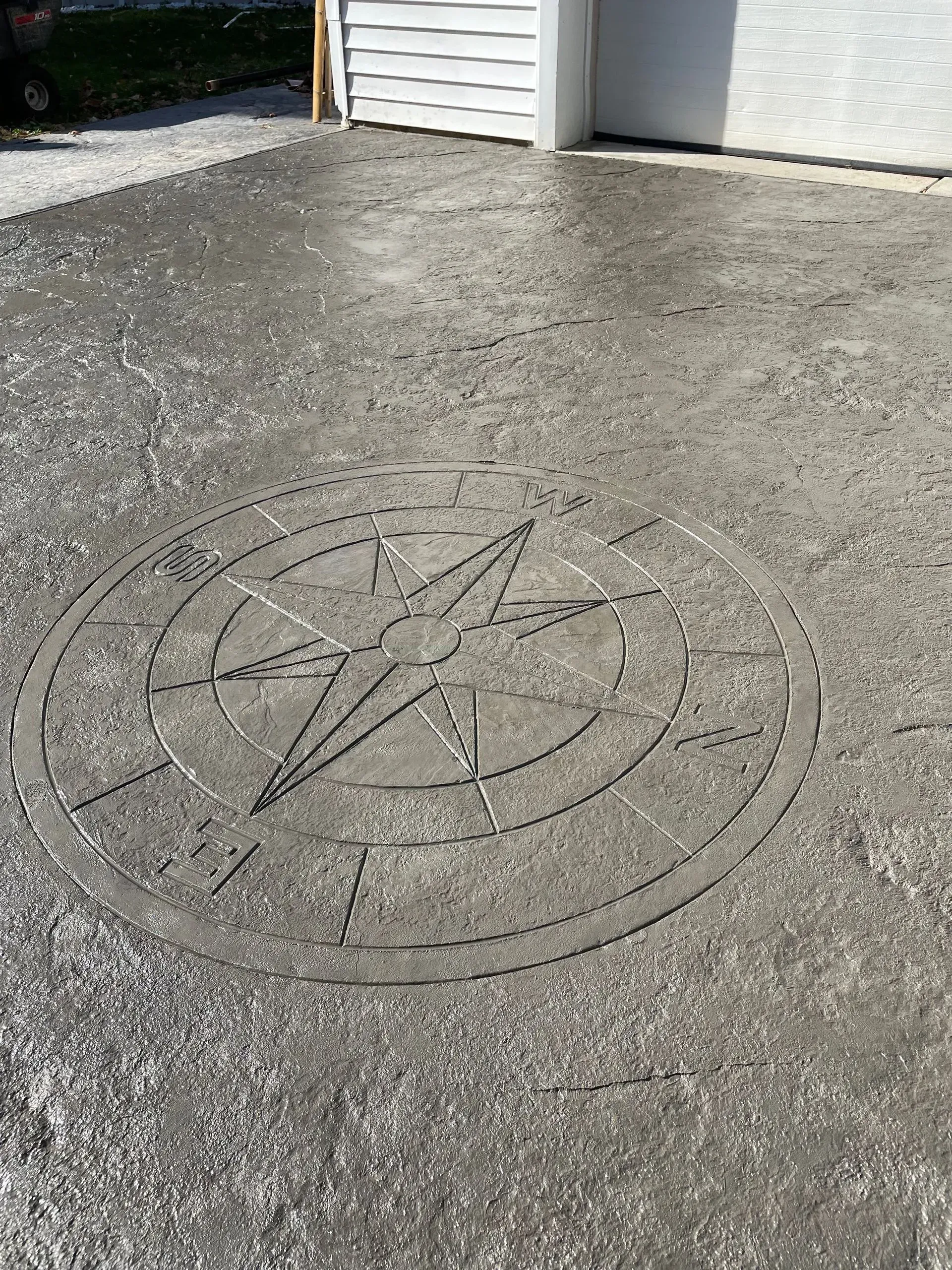 Compass rose design etched into a concrete surface.