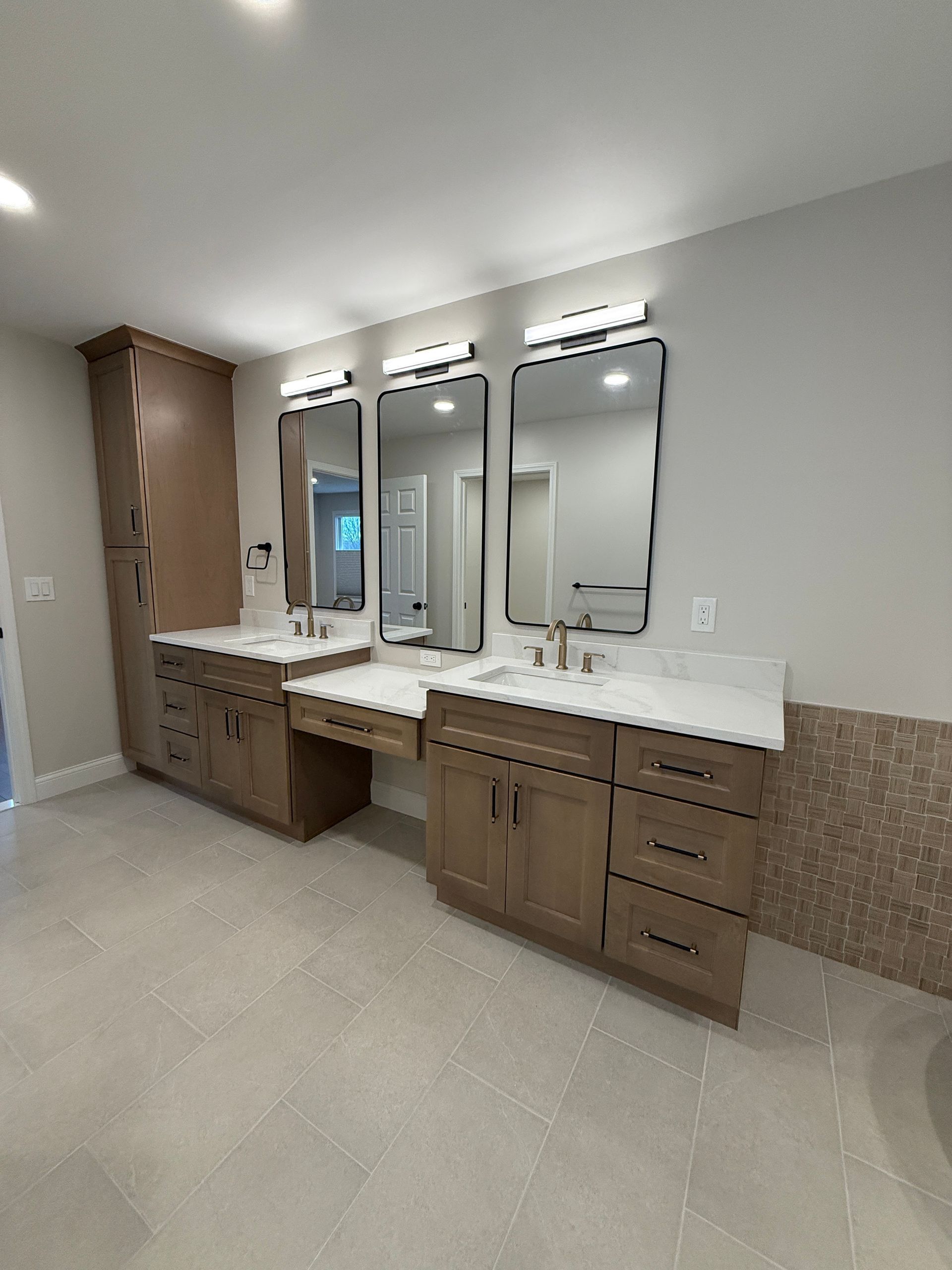 Modern bathroom vanity with double sinks, mirrors, and beige tile flooring