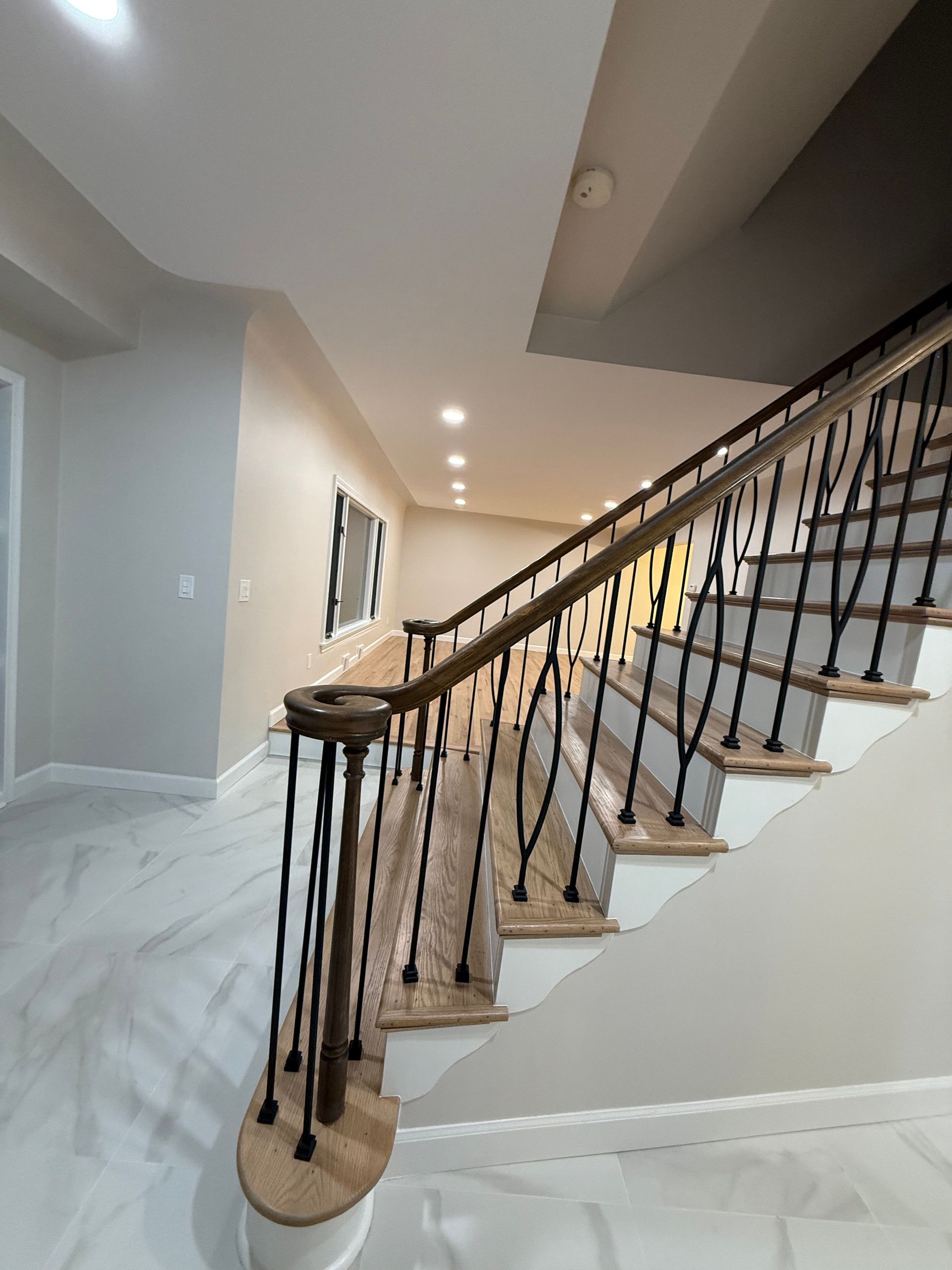Interior staircase with black railing and carpeted steps in a modern hallway