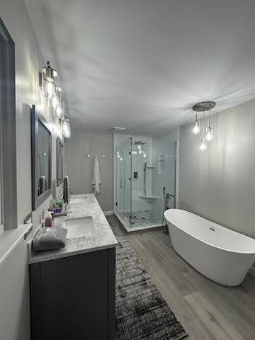 Modern bathroom with double vanity, glass shower, and freestanding tub in white and gray tones