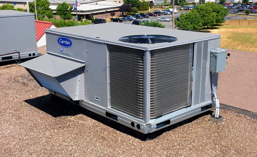 A carrier air conditioner is sitting on the roof of a building