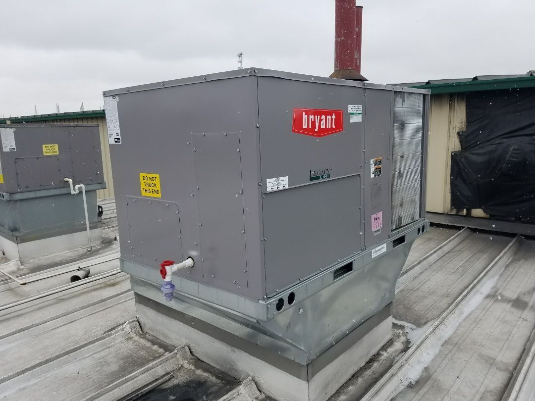 A large air conditioner is sitting on top of a roof.