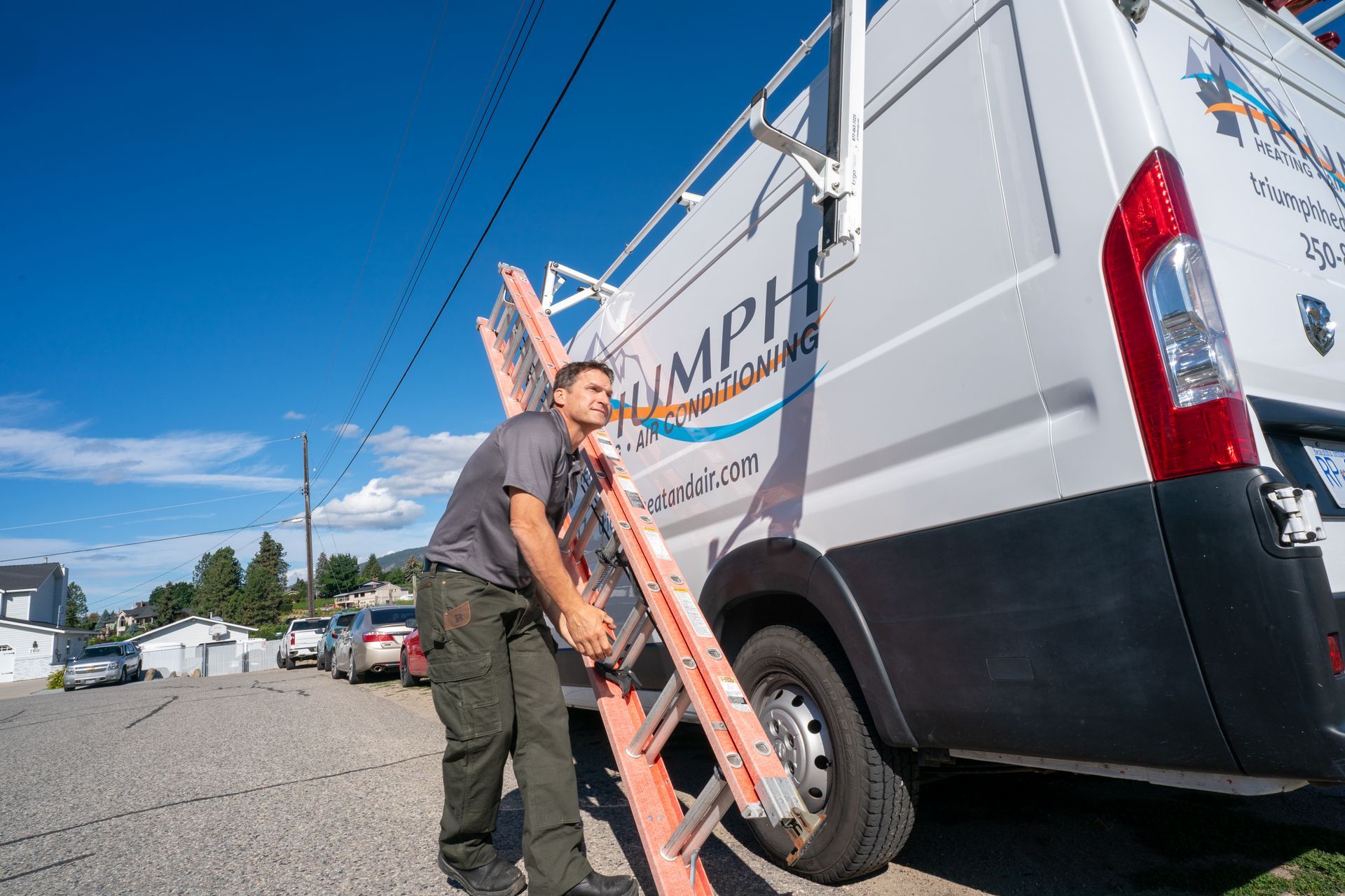 Triumph technician standing in front of a van with boxes in front of it.