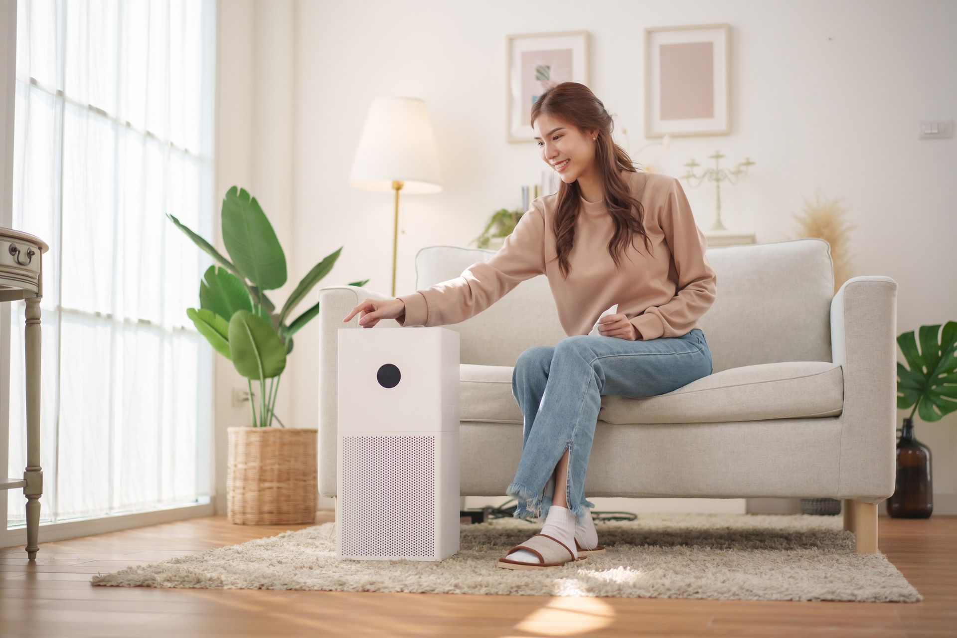 Person using air purifier in bright Okanagan home to improve indoor air quality.
