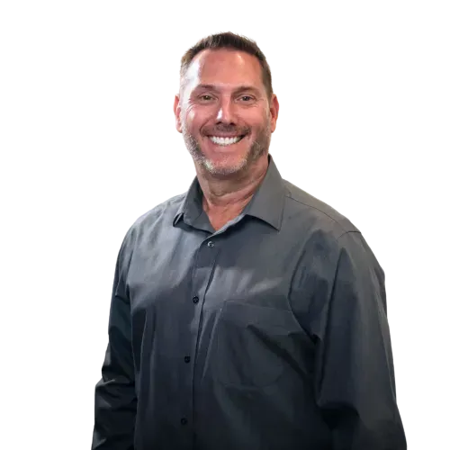 Smiling man in a dark gray button-up shirt against a white background
