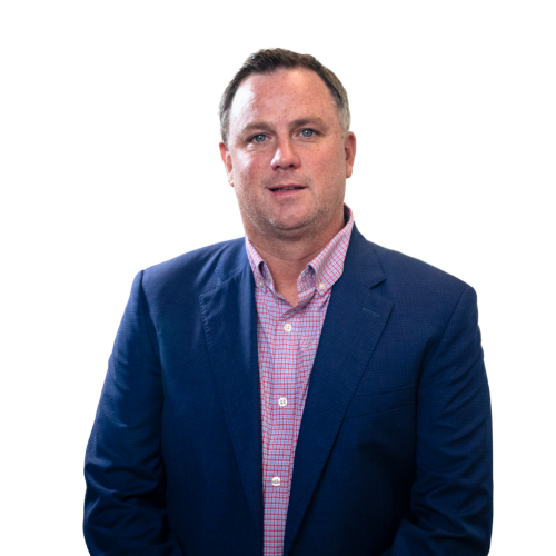 Man in a blue blazer and pink checkered shirt standing against a white background
