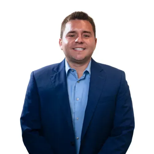 Smiling man in a blue suit and light blue shirt against a white background