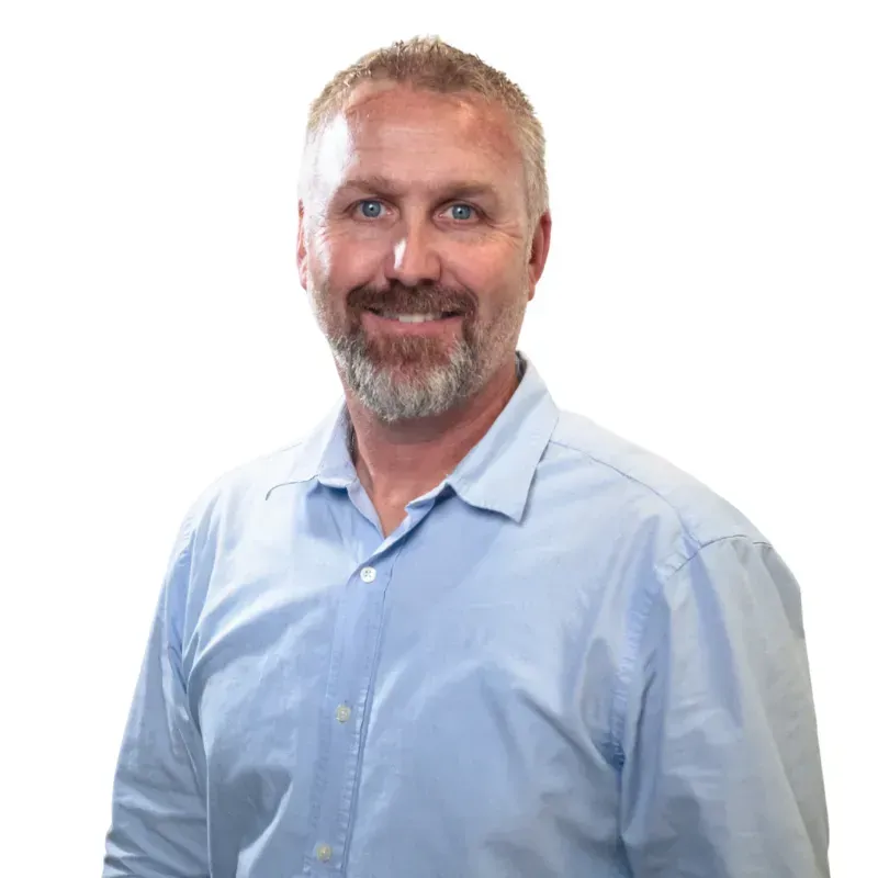 Smiling man in a light blue button-down shirt against a white background