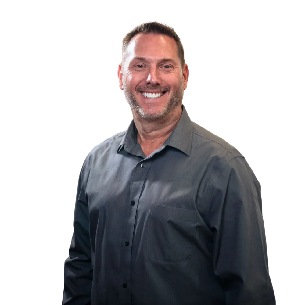 Smiling man in a dark gray button-up shirt against a white background