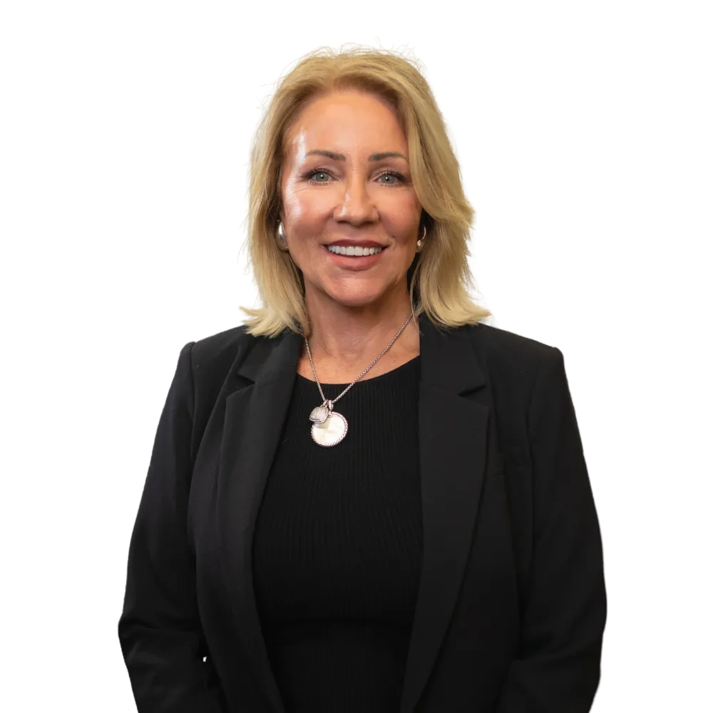 Smiling woman in a black blazer and necklace against a white background