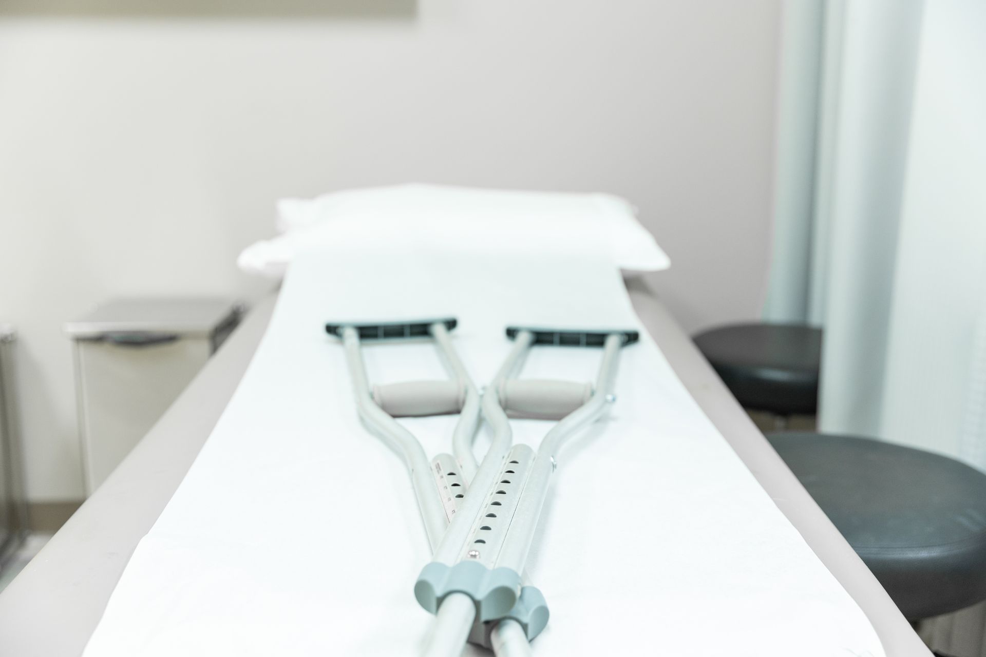 A pair of crutches sitting on top of a hospital bed.